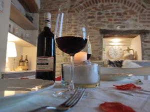 een glas wijn op een tafel met een fles wijn bij Borgo in Città in Pistoia