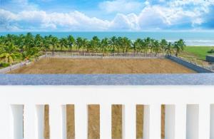 einen weißen Zaun mit Blick auf den Strand in der Unterkunft Pranaav Beach Resort in Puducherry