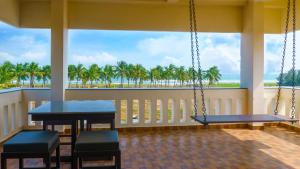 eine Veranda mit Schaukeln und Meerblick in der Unterkunft Pranaav Beach Resort in Puducherry