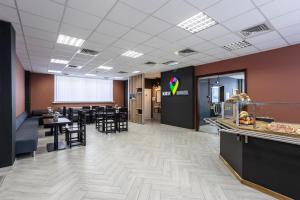 une salle à manger avec des tables et des chaises ainsi qu'une cafétéria dans l'établissement Kyiv Hotel, à Kiev