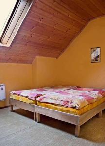 een bed in een kamer met een houten plafond bij Holiday home in Cerna v Posumavi 1908 in Černá v Pošumaví