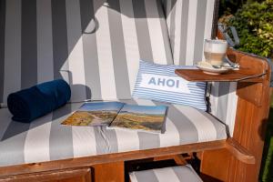 een stoel met een tafel en een boek erop bij Das Frühstückshotel Büsum in Büsum