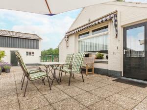 een patio met een tafel en stoelen bij Cozy Holiday Home in Oisterwijk with Swimming Pool in Oisterwijk