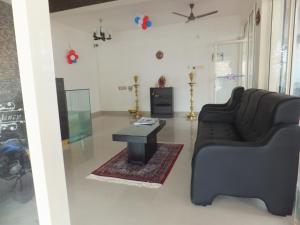 sala de estar con sofá y mesa en KV Residency, en Coimbatore