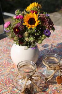 un vaso bianco con un mazzo di fiori su un tavolo di FeWo "Regnitztraum" in Forchheim - 3-Zimmer-Apartment - 2 Schlafzimmer a Forchheim