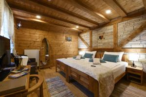 een slaapkamer met een groot bed in een houten kamer bij Ethno Houses Plitvice Lakes Hotel in Plitvica selo