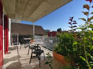 un patio con mesas y sillas en el balcón en B&B Perron13, en Murten