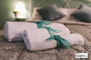 uma pilha de toalhas dobradas numa cama em CHAPLIN Luxury Holiday House em Viterbo