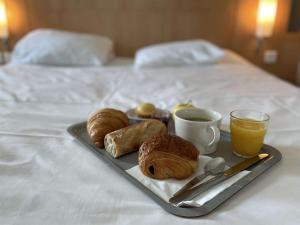 - un plateau de viennoiseries et de café sur le lit dans l'établissement ibis Rennes Beaulieu, à Cesson-Sévigné