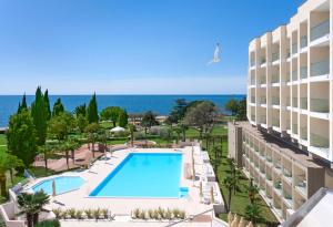 Vom Balkon eines Hotels genießen Sie Poolblick. in der Unterkunft Hotel Materada Plava Laguna in Poreč