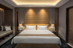 a bedroom with a large bed and two lamps at Sutasoma Hotel in Jakarta