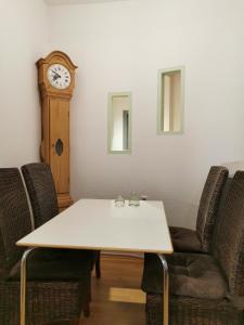 een tafel met stoelen en een klok in een kamer bij Die Birke in Bremen