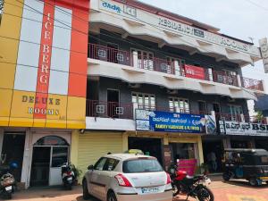 a white car parked in front of a building at Ice Berg Deluxe Lodge in Kushālnagar