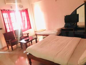 a bedroom with a bed and a desk and a television at Ice Berg Deluxe Lodge in Kushālnagar