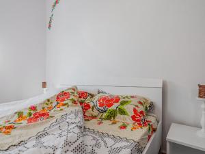 a white bed with floral pillows on it at Casa de vacanta traditionala romaneasca in Schiuleşti