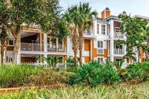 um edifício de apartamentos com árvores e plantas em Sandestin Baytowne Wharf - Observation Point South #471 em Destin