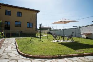 a patio with an umbrella and a table and chairs at Apartamentos Alegría in Santillana del Mar