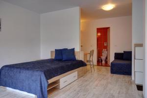 a bedroom with a bed and a couch and a chair at Vila Alba Brasov in Braşov