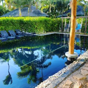 una casa y una piscina con sillas y árboles en Casa Barbara, en Las Terrenas