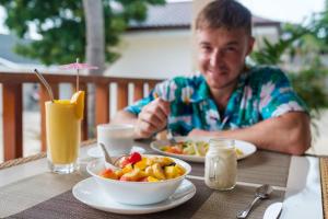 莫阿尔博阿Cebu Seaview Dive Resort的坐在桌子上吃一碗食物的人