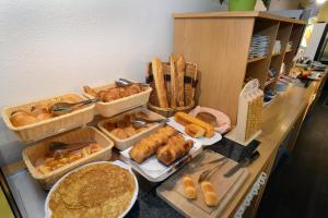 a buffet with baskets of bread and pastries on a counter at Hotel inn Dijon-Quetigny in Quétigny