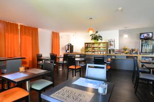 a restaurant with tables and chairs and a bar at Hotel inn Dijon-Quetigny in Quétigny