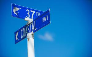 dois sinais de rua azuis em cima de um poste em Castle in the Sand em Ocean City