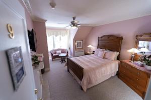 um quarto com uma cama e uma cadeira num quarto em The Maple Inn em Parrsboro