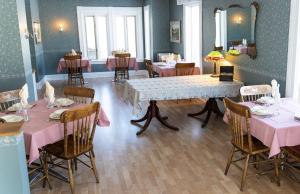 uma sala de jantar com mesas e cadeiras cor-de-rosa e um espelho em The Maple Inn em Parrsboro