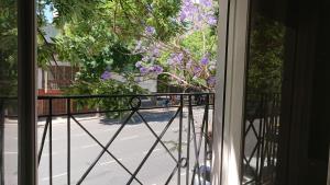 ブエノスアイレスにある534 Petit San Telmo - Studio & Suitesの紫の花の木のあるバルコニーからの眺め