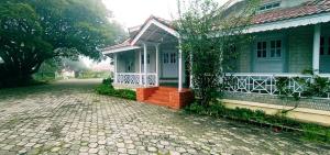 a house with a porch and a brick driveway at Bruton resorts in Kodaikānāl