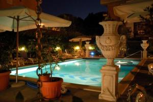 una piscina con vaso e ombrellone di Hotel Flowers a Montecatini Terme