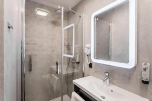 a bathroom with a shower and a sink and a mirror at Hotel Vesper House in Gdańsk