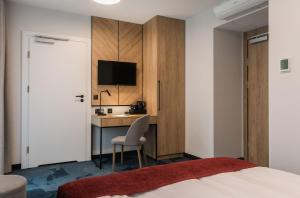 a hotel room with a desk and a bed at Hotel Vesper House in Gdańsk