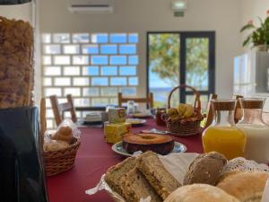 un tavolo con pane, succo d'arancia e bottiglie di latte di Albergue da Juventude a Tancos