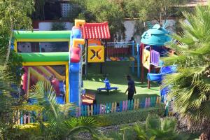 ein farbenfroher Spielplatz mit einer Person, die davor läuft in der Unterkunft Meru Slopes Hotel in Meru