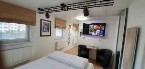 - une chambre avec un lit et une télévision murale dans l'établissement Aparthotel 3 ,, Cosy House Studio'' & Parking, à Kaunas