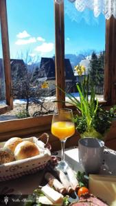 una mesa con un plato de comida y un vaso de zumo de naranja en Willa Blanca Zakopane, en Zakopane