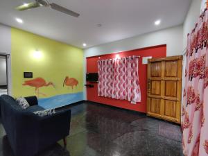 un soggiorno con parete rossa e verde di Royal Wings Apartments a Mysore