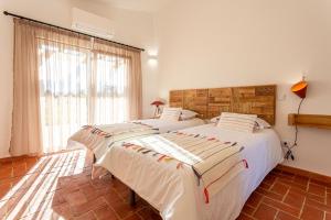 2 camas individuales en una habitación con ventana en Cerro da Campaniça, en Santiago do Cacém