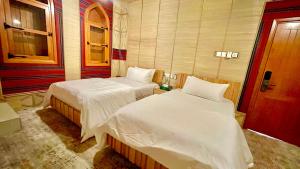 Giường trong phòng chung tại Fort Guesthouse نُزل القلعة