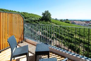 una terrazza con due sedie e una recinzione di Best Western Hotel & SPA Le Schoenenbourg - Riquewihr - Proche Colmar a Riquewihr