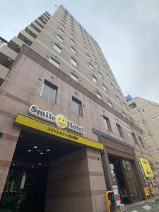 a building with a hotel sign on the front of it at Smile Hotel Nagoya Sakae in Nagoya