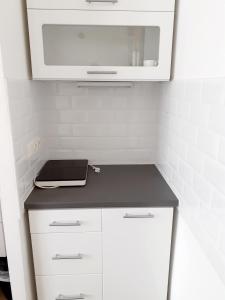 a kitchen with white cabinets and a microwave at Sissi Apartments in Achau