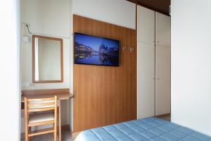 a bedroom with a flat screen tv on the wall at Hotel Ancora in Lido di Jesolo