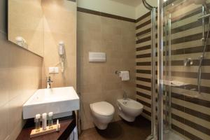 a bathroom with a sink and a toilet and a shower at Hotel Ancora in Lido di Jesolo