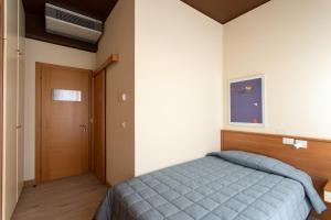 a bedroom with a blue bed and a door at Hotel Ancora in Lido di Jesolo