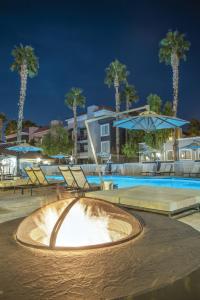 una fuente en una piscina por la noche con palmeras en Desert Rose Resort, en Las Vegas