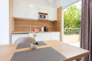 a kitchen with a table with a vase of flowers on it at Villa King Apartments in Brela