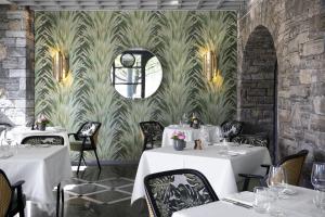 un restaurante con mesas blancas y un mural en la pared en Castello del Sole Beach Resort&SPA, en Ascona